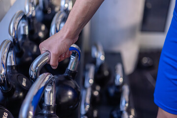 closeup hand of athlete gripping kettlebell for strength training in gym