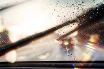 Rain on car windshield while driving on a highway