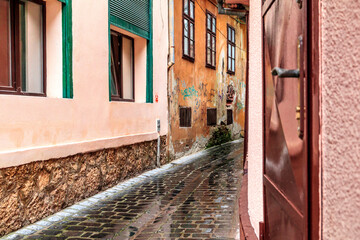 Europe, Romania. Brasov. Rain on narrow cobblestone passageway. Reflections.