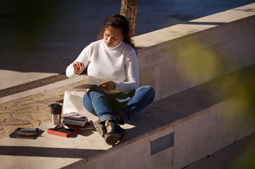 Woman drawing outdoors enjoying a sunny day in the park