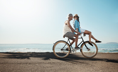 Obraz premium Happy, ocean and couple on bicycle on promenade, holiday and summer vacation for bonding together. Travel, dating and man and woman cycling on bike for journey, relaxing and fun adventure in Miami