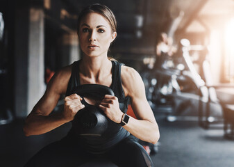 Woman, kettlebell and workout in gym with fitness for core strength, endurance training or power...