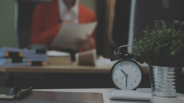Stressed and tired Asian woman office worker working at her desk in the dark office at night. Asian business woman working overtime in lamplight