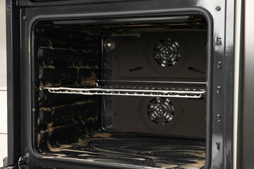 Obraz premium Open electric oven covered with cleaning foam in kitchen