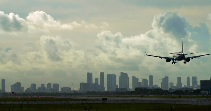 Plane Lands at Miami Airport Under Dramatic Cloudy Sky