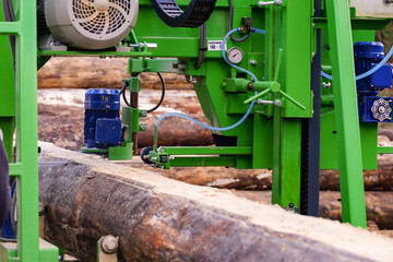Process of machining log in machine closeup. Outdoor scene featuring saw equipment cutting through...
