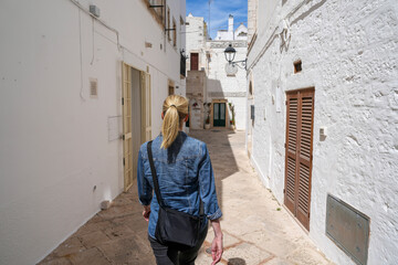 Woman walking in quiet alley in Locorotondo