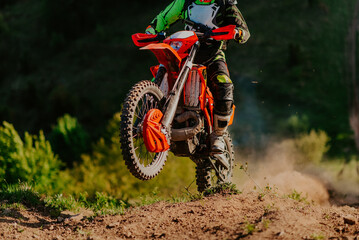 Professional enduro bike rider on action, dirt ride on the muddy road. Motocross sport.