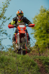 Professional enduro bike rider dirt ride on the muddy road. Motocross sport.