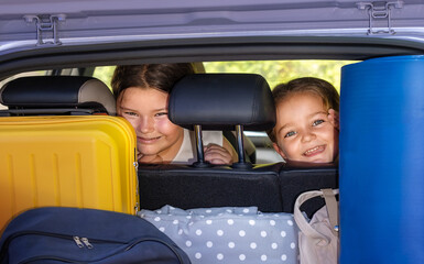 Portrait of sisters' children looking into the trunk