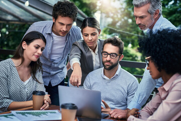 Obraz premium Business people, laptop and together at cafe meeting, communication and website for plan. Staff, team building and support or collaboration on project, talking and brainstorming ideas at restaurant
