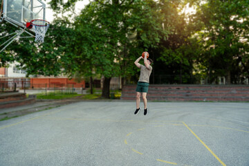 Fototapeta premium Young man on basketball practice, shooting on a basket all by himself
