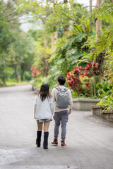 In March, a Taiwanese woman in her twenties and a Hong Kong man are walking in a lush botanical garden in Zhongzheng District, Taipei City, Taiwan.