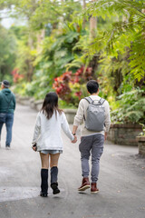 Fototapeta premium In March, a Taiwanese woman in her twenties and a Hong Kong man are walking in a lush botanical garden in Zhongzheng District, Taipei City, Taiwan.