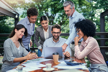 Business people, laptop and proposal at cafe meeting, communication and website for plan. Staff, team building and support or collaboration on project, speaking and brainstorming ideas at restaurant