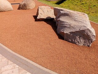 Large stone boulders on the bed of brown color. Landscape design of the yard. Special cork covering of the surface in the yard. © Олег Струс
