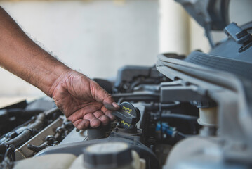 Close up Car Mechanic man hands repairing car auto repair shop. Man hands fixing machinery vehicle mechanical service. open vehicle hood checking up auto mobile. Vehicle Car maintenance engineer.