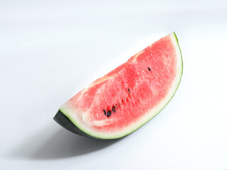 Watermelon, a fresh summer fruit, is cut open on a white table