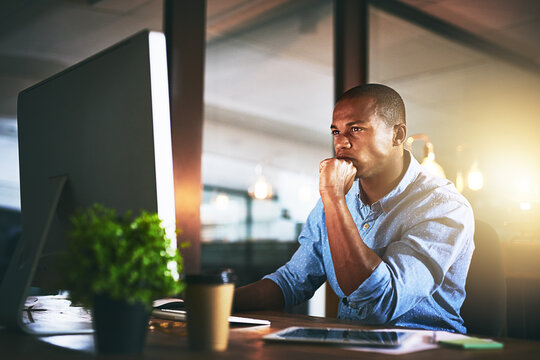 Thinking, computer and business black man at night for website, research and reading news in office. Creative, developer and worker online for software update, networking and working on web design