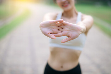 Naklejka premium Sportswoman. Fit young Asian woman with sportswear stretching muscle in park before running and enjoying healthy outdoor. Fitness runner girl in public park. Wellness being concept