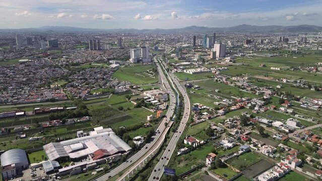 Road distributor with transport vehicles in panorama of the city of Puebla