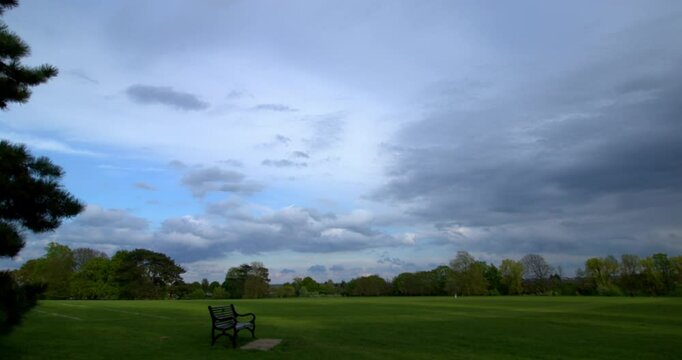 Time lapse of sunset clouds on a sunny summer day with Avery Hill House in Avery Hill Park, in London, UK