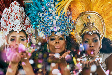 Confetti, carnival and portrait of women in Brazil with fashion, blowing kiss and party in city. Festival, show girls and glitter at parade for celebration, costume and traditional samba dancers