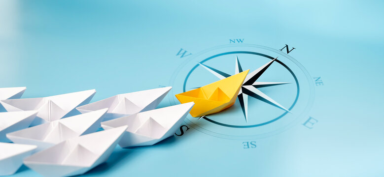 Yellow Paper Boat With Compass Leaving Mainstream And Changing Direction.