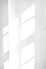 Obraz premium Empty white wall where sunlight shining through a window