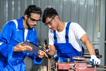 Two engineers collaborating on project in industrial setting, reviewing documents and discussing technical details teamwork, engineering and industrial operations with machinery and tool manufacturing