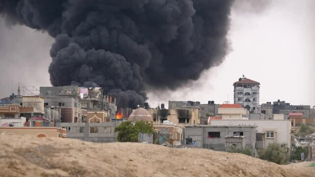 Thick black smoke rising from a building destroyed by Israeli rocket in Rafah