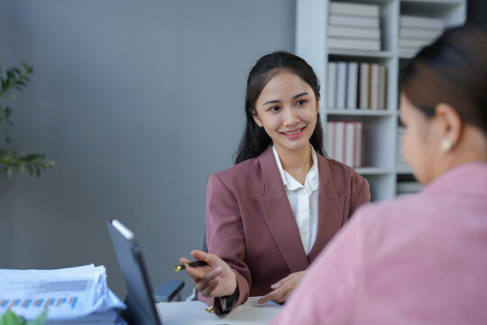 Asian female sales representatives in the section of Real estate talked and discussed tax plans to search for information Ask questions and give advice. All information is recorded and detailed.