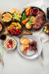 Table with grilled food. Pizza, corn, tomatoes, peppers, cooked meat. BBQ time