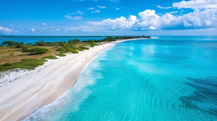 Obraz premium High-angle view of a peaceful beach, showcasing a long and wide stretch of white sand along the coastline, perfectly framed by the crystal-clear blue waters, offering a serene and rejuvenating scene