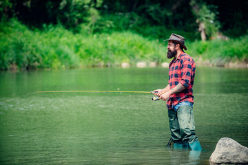 Fisherman using rod flyfishing in mountain river. A fly fisherman fishing for wild trout on the river in the forest.