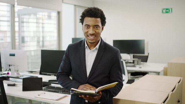 In a modern office setting, a young professional reading a book emphasizes the importance of success and teamwork in todays corporate environment, embodying key values within the company