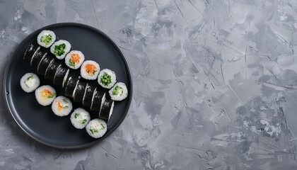 Overhead view of platter of sushi rolls on gray cement background