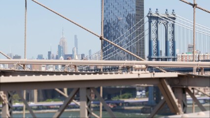 Obraz premium New York City Manhattan Bridge from Brooklyn Bridge view. Empire State building in Midtown. USA travel landmark, NYC skyline cityscape. Iconic architecture thru cables. Visit United States of America.