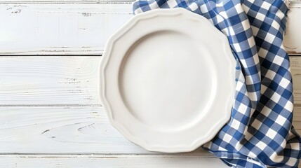 Empty white plate on wooden white table with checkered blue linen napkin. Flat lay, top view, copy space