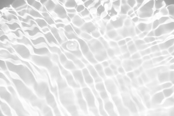 White water with ripples on the surface. Defocus blurred transparent white colored clear calm water surface texture with splashes and bubbles. Water waves with shining pattern texture background.