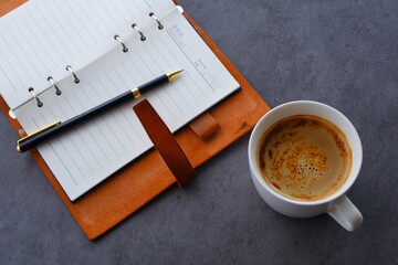 ミルクをたっぷり入れたコーヒー、カフェ・ラッテを飲みながら、日記をつけているイメージ
