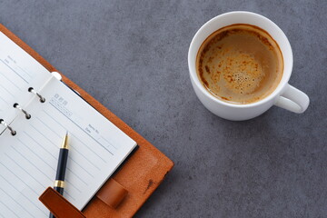 ミルクをたっぷり入れたコーヒー、カフェ・ラッテを飲みながら、日記をつけているイメージ
