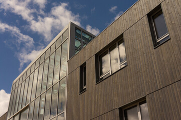 Modern architecture fa&ccedil;ade made of glass and dark wood and windows