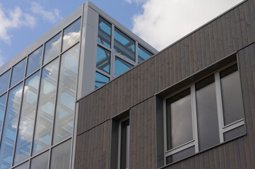 Modern architecture façade made of glass and dark wood and windows