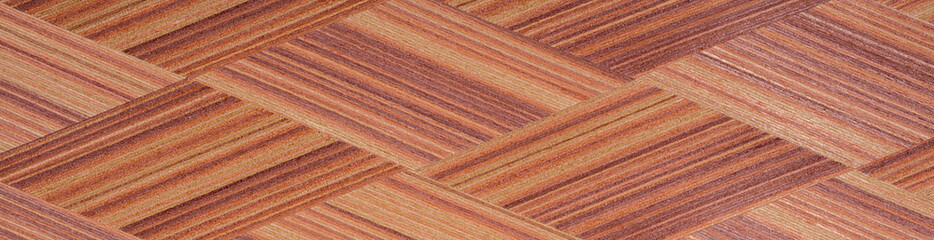 Interwoven mahogany strips reveal a rich tapestry of burnt sienna and copper, artfully aligned in a herringbone allure