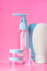 Travel-Sized Bottles of Lotion, Shampoo, and Conditioner on Pink Background