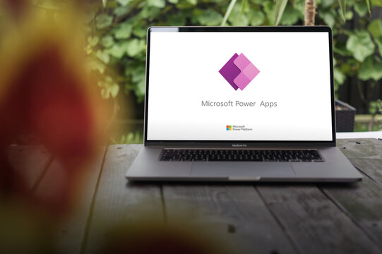 Microsoft Power Apps logo, which enables building professional-grade apps and automating workflows without additional coding, displayed on MacBook Pro screen