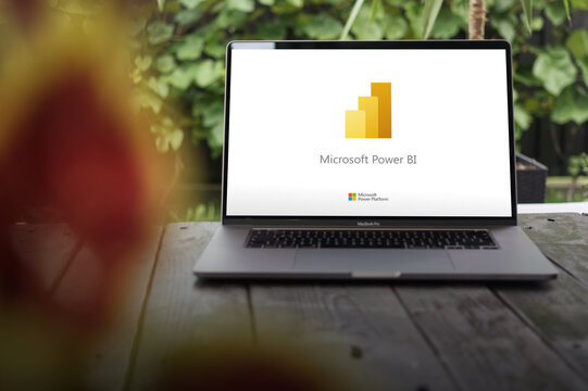 Microsoft Power BI logo, stunning reports and real-time insights from across your organization, displayed on MacBook Pro screen