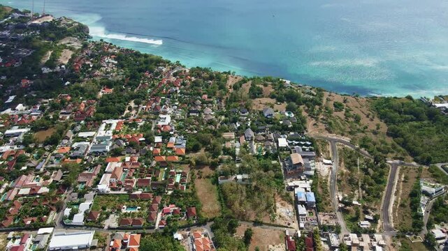 Aerial view of Bingin Beach surrounded with luxury resorts and real estate located at the top of the cliff, Indonesia