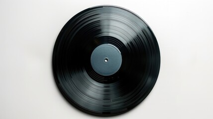 Obraz premium A black vinyl record displayed prominently on a white wall, perfect for use in music-themed designs or as a decorative element